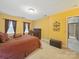 Inviting bedroom with comfortable bed, ample natural light, neutral carpet and yellow walls at 2223 Jon Chris Dr, Harrisburg, NC 28075