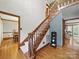 Elegant foyer showcasing a hardwood staircase with wood trim and hardwood flooring throughout the entryway at 2223 Jon Chris Dr, Harrisburg, NC 28075