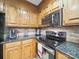 Close up of stainless steel stove, granite counter top and wooden cabinets at 2223 Jon Chris Dr, Harrisburg, NC 28075