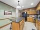 A kitchen with a granite island, wooden cabinets, black appliances and decorative green walls at 2223 Jon Chris Dr, Harrisburg, NC 28075