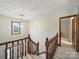 Carpeted staircase with wooden banister leads to a hallway with natural light streaming through a window at 2223 Jon Chris Dr, Harrisburg, NC 28075