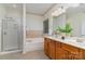 Bright bathroom featuring a soaking tub, glass shower, and double sink vanity with wood cabinets at 2504 Korbel Ct, Waxhaw, NC 28173
