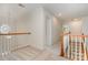 Bright upstairs hallway with wood banister and railing; natural light from arched window and doorway at 2504 Korbel Ct, Waxhaw, NC 28173