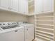 Laundry room with white cabinets, shelves, washer, and dryer at 2504 Korbel Ct, Waxhaw, NC 28173