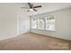 Bright bedroom featuring three windows, neutral walls, and a ceiling fan at 2515 Walnut Forest Dr, Charlotte, NC 28216