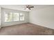 A carpeted bedroom featuring natural lighting through a set of windows and a ceiling fan at 2515 Walnut Forest Dr, Charlotte, NC 28216