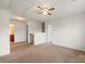 A large carpeted bedroom with a ceiling fan and two doors leading to the hallway and bathroom at 2515 Walnut Forest Dr, Charlotte, NC 28216