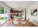 Cozy breakfast nook with hardwood floors, a modern light fixture, a glass table, and sliding glass doors to the yard at 2515 Walnut Forest Dr, Charlotte, NC 28216