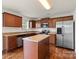 Well-lit kitchen features stainless steel appliances, brown cabinetry, and a kitchen island at 2515 Walnut Forest Dr, Charlotte, NC 28216