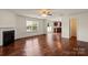 Open-concept living room with hardwood floors, a fireplace, crown molding, base molding, and access to the kitchen at 2515 Walnut Forest Dr, Charlotte, NC 28216