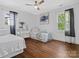 Bright bedroom with hardwood floors, a ceiling fan, and large windows overlooking a serene outdoor view at 2633 N Sharon Amity Rd, Charlotte, NC 28205