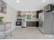 Modern kitchen featuring stainless steel appliances, dark cabinets, and a stylish tile backsplash at 2633 N Sharon Amity Rd, Charlotte, NC 28205