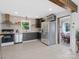 Bright kitchen featuring stainless steel appliances, dark wood cabinets, and tile backsplash at 2633 N Sharon Amity Rd, Charlotte, NC 28205