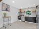 Well-lit kitchen with updated appliances, custom cabinetry, tile backsplash, and convenient shelving at 2633 N Sharon Amity Rd, Charlotte, NC 28205