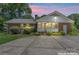 Brick and vinyl siding home featuring a back yard, concrete patio, and lush landscaping enhanced at 2715 Kennetuck Ct, Charlotte, NC 28273
