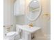 Bathroom featuring a pedestal sink, oval mirror, and wallpapered walls, as well as grab bars for accessibility at 2715 Kennetuck Ct, Charlotte, NC 28273