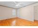 Bedroom with hardwood floors, shuttered windows, ceiling fan, and open closet to hall at 2715 Kennetuck Ct, Charlotte, NC 28273