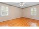 Bedroom featuring hardwood floors, two shuttered windows, and a ceiling fan at 2715 Kennetuck Ct, Charlotte, NC 28273