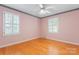 Bedroom featuring two windows with shutters, hardwood floors, and a ceiling fan at 2715 Kennetuck Ct, Charlotte, NC 28273