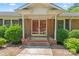 Charming brick home entrance with a covered front porch, wrought iron railing, and manicured shrubs at 2715 Kennetuck Ct, Charlotte, NC 28273
