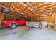 Spacious garage featuring exposed wooden beams, ample storage, and a red truck parked inside at 2715 Kennetuck Ct, Charlotte, NC 28273