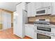 Kitchen featuring white cabinets, modern appliances, and decorative wallpaper at 2715 Kennetuck Ct, Charlotte, NC 28273