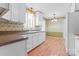 Cozy kitchen featuring white cabinetry, laminate countertops, and charming wallpaper at 2715 Kennetuck Ct, Charlotte, NC 28273