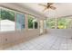 Bright sunroom with tile flooring, ceiling fan, and multiple windows offering outdoor views at 2715 Kennetuck Ct, Charlotte, NC 28273