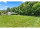 View of the expansive green yard with a detached garage, surrounded by mature trees at 2715 Kennetuck Ct, Charlotte, NC 28273