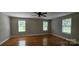 Spacious bedroom with hardwood floors, three windows, and a ceiling fan, providing ample light and comfort at 2820 Bellhaven Cir, Charlotte, NC 28214