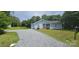 Charming blue home featuring a gravel driveway, manicured lawn, and mature trees at 2820 Bellhaven Cir, Charlotte, NC 28214