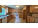 Eat-in kitchen with honey toned wood cabinets, tile backsplash, and white appliances at 2820 Bellhaven Cir, Charlotte, NC 28214