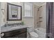 Tiled bathroom showcasing a granite countertop, framed mirror, shower with tiled walls, and modern toilet at 2835 Berkhamstead Cir, Concord, NC 28027