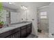 Bright bathroom with double vanity, granite countertop, framed mirrors, and shower with patterned curtains at 2835 Berkhamstead Cir, Concord, NC 28027