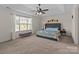 Comfortable primary bedroom featuring a ceiling fan, tray ceiling, and large window at 2835 Berkhamstead Cir, Concord, NC 28027