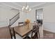 Bright dining room showcasing hardwood floors, wainscoting, and views of the kitchen and staircase at 2835 Berkhamstead Cir, Concord, NC 28027