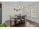 Elegant dining room featuring a modern chandelier, wainscoting, and abundant natural light from large windows at 2835 Berkhamstead Cir, Concord, NC 28027