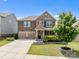 Charming two-story house with stone accents, a well-manicured lawn, and a spacious driveway at 2835 Berkhamstead Cir, Concord, NC 28027