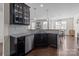 Modern kitchen featuring dark cabinets, granite countertops, stainless steel appliances, and open dining area at 2835 Berkhamstead Cir, Concord, NC 28027