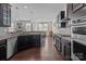 Open concept kitchen with dark cabinets, granite countertops, and stainless steel appliances flowing into the dining area at 2835 Berkhamstead Cir, Concord, NC 28027