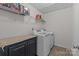 Functional laundry room with washer, dryer, overhead shelving, and a storage cabinet for organized chores at 2835 Berkhamstead Cir, Concord, NC 28027