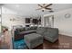 Spacious living room featuring hardwood floors, a large sectional couch, and open access to kitchen at 2835 Berkhamstead Cir, Concord, NC 28027