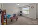 Spacious carpeted office with computer setup, unique chairs, coffee table, and ample natural light at 2835 Berkhamstead Cir, Concord, NC 28027
