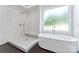 Modern bathroom with stand alone tub, a walk-in shower with marble walls and a frosted window at 3078 Mountain Creek Dr, Sherrills Ford, NC 28673