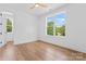 Light-filled bedroom with hardwood floors and a large window showcasing the outdoor scenery at 3078 Mountain Creek Dr, Sherrills Ford, NC 28673