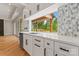 White cabinetry, stone counters, and hexagon backsplash with view of covered porch through kitchen window at 3078 Mountain Creek Dr, Sherrills Ford, NC 28673