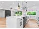 Bright, modern kitchen with large island, beverage fridge, and stylish fixtures and sliding doors to outside patio at 3078 Mountain Creek Dr, Sherrills Ford, NC 28673
