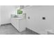 Laundry room boasts a sink, gray floors and backsplash, white cabinets, and natural light at 3078 Mountain Creek Dr, Sherrills Ford, NC 28673