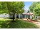 The backyard features a lounge area and garden with lush green trees and a lawn at 314 Center Dr, Davidson, NC 28036