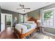 Traditional bedroom featuring a wooden king bed, overhead fan, and patterned curtains at 314 Center Dr, Davidson, NC 28036